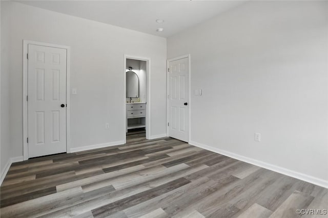 1114 Hinton St, Petersburg, VA 23803 - unfurnished bedroom featuring wood finished floors, baseboards, and connected bathroom