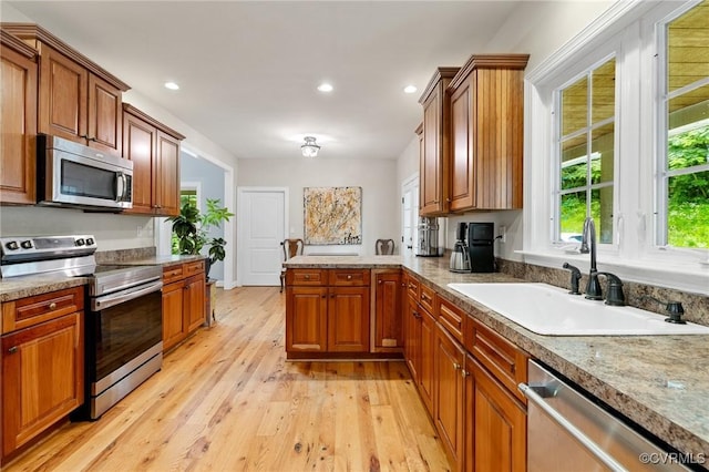 11021 Grub Hill Church Rd, Amelia Courthouse, VA 23002 - kitchen featuring appliances with stainless steel finishes, light wood-style floors, a peninsula, recessed lighting, and brown cabinets
