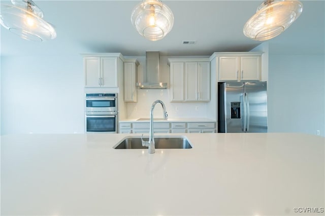 4302 Weaver Brook Rd Unit B, Glen Allen, VA 23233 - kitchen with stainless steel appliances, wall chimney exhaust hood, a sink, light countertops, and hanging light fixtures