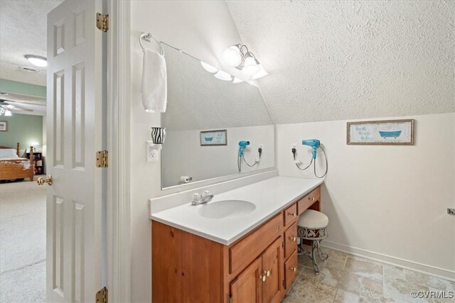 2024 Judes Ferry Rd, Powhatan, VA 23139 - bathroom featuring a textured ceiling, vanity, baseboards, vaulted ceiling, and connected bathroom