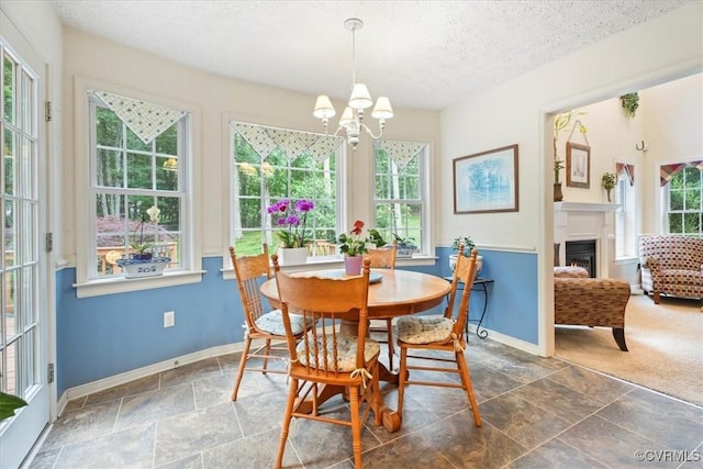 2024 Judes Ferry Rd, Powhatan, VA 23139 - dining room featuring a chandelier, baseboards, a textured ceiling, stone finish flooring, and a lit fireplace