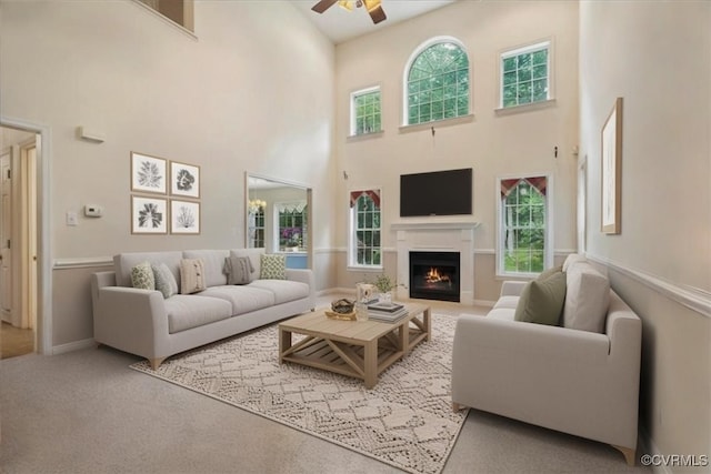 2024 Judes Ferry Rd, Powhatan, VA 23139 - carpeted living room with ceiling fan, a high ceiling, and a lit fireplace
