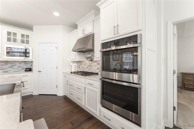 4025 Carrie Mill Xing, Glen Allen, VA 23059 - kitchen featuring stainless steel appliances, under cabinet range hood, white cabinets, backsplash, and dark wood-style floors
