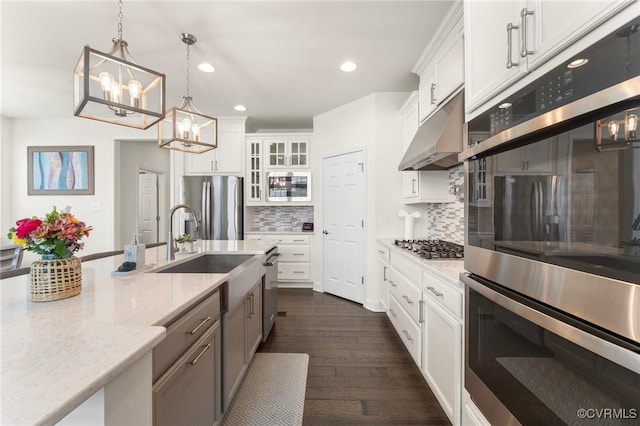 4025 Carrie Mill Xing, Glen Allen, VA 23059 - kitchen with appliances with stainless steel finishes, a chandelier, under cabinet range hood, backsplash, and glass insert cabinets