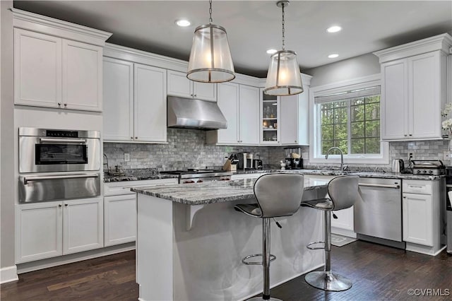 5217 Aldenbrook Way, Henrico, VA 23059 - kitchen featuring a warming drawer, under cabinet range hood, stainless steel appliances, dark wood-type flooring, and light stone countertops