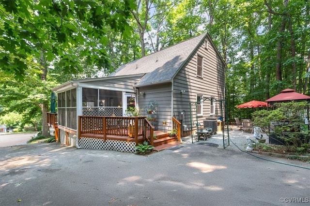 7503 Native Dancer Dr, Midlothian, VA 23112 - view of front of house with a sunroom, a patio area, roof with shingles, and a wooden deck