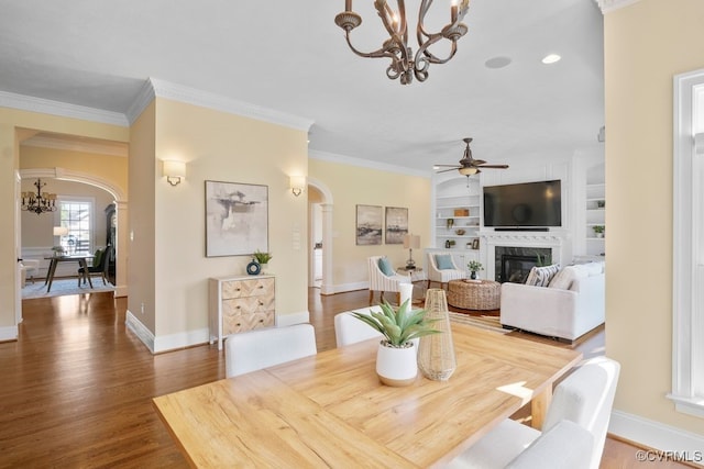 12316 Traylor Field Ln, Ashland, VA 23005 - dining room featuring arched walkways, a chandelier, a high end fireplace, wood finished floors, and crown molding