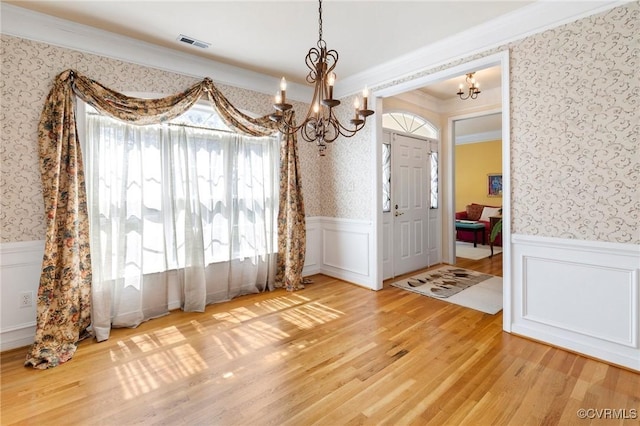 9401 Nolandwood Dr, Mechanicsville, VA 23116 - unfurnished dining area with a chandelier, wallpapered walls, ornamental molding, light wood-style floors, and a wainscoted wall