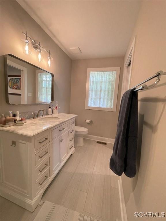 1710 N 29th St, Richmond, VA 23223 - bathroom with vanity, toilet, and baseboards