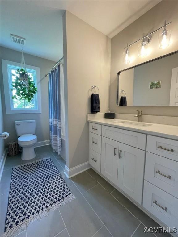 1710 N 29th St, Richmond, VA 23223 - bathroom featuring vanity, tile patterned floors, toilet, baseboards, and shower / bath combo