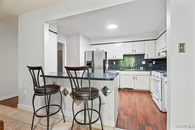 2911 Ennismore Ct, Chesterfield, VA 23224 - kitchen with white gas range, stainless steel refrigerator with ice dispenser, dark countertops, and dark wood-style flooring