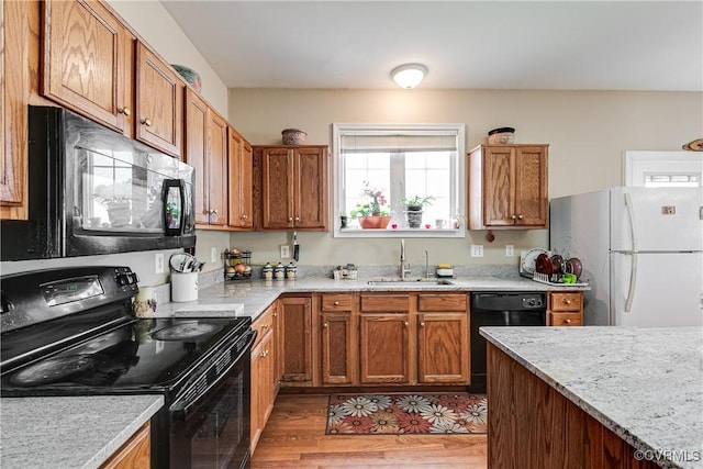 1408 Selma Ln, Henrico, VA 23223 - kitchen with black appliances, a sink, light wood finished floors, and brown cabinetry
