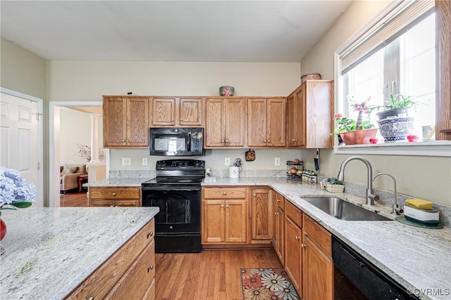 1408 Selma Ln, Henrico, VA 23223 - kitchen with black appliances, a sink, light wood-style floors, light stone countertops, and brown cabinetry
