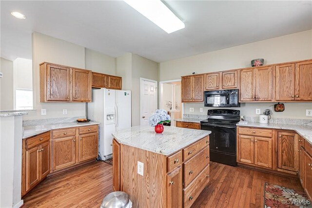 1408 Selma Ln, Henrico, VA 23223 - kitchen featuring black appliances, dark wood finished floors, a kitchen island, light stone counters, and brown cabinets