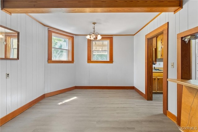 672 Main St, Dillwyn, VA 23936 - spare room featuring light wood-type flooring, a chandelier, crown molding, baseboards, and wood walls