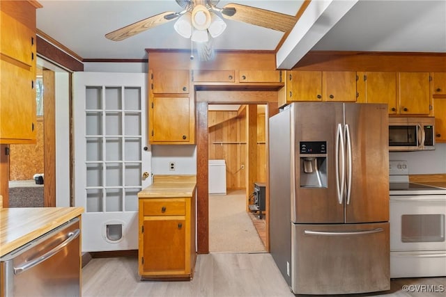 672 Main St, Dillwyn, VA 23936 - kitchen featuring appliances with stainless steel finishes, ceiling fan, brown cabinets, light wood finished floors, and crown molding