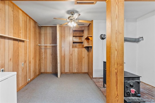 672 Main St, Dillwyn, VA 23936 - interior space featuring wood walls, a wood stove, carpet floors, and baseboards