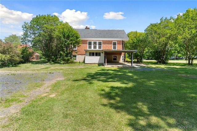 672 Main St, Dillwyn, VA 23936 - back of property featuring brick siding, a chimney, a lawn, driveway, and a carport