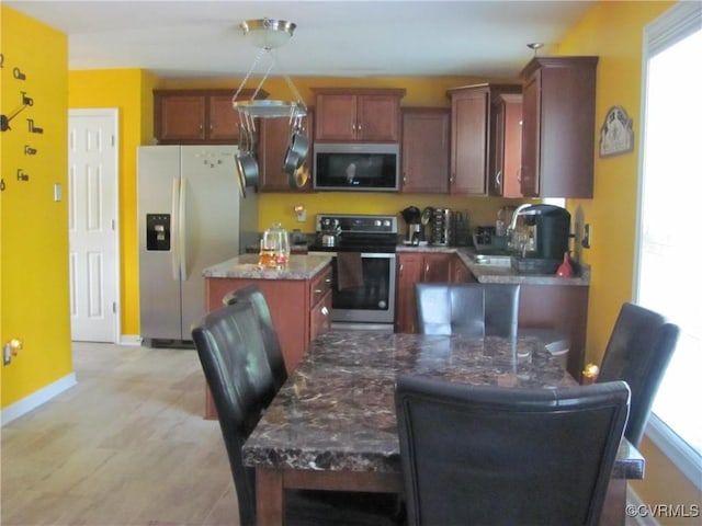 11506 Charles Towne Rd, Midlothian, VA 23112 - kitchen featuring appliances with stainless steel finishes, a center island, baseboards, stone counters, and light wood-style floors
