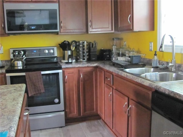 11506 Charles Towne Rd, Midlothian, VA 23112 - kitchen featuring appliances with stainless steel finishes, a sink, light countertops, and light tile patterned floors