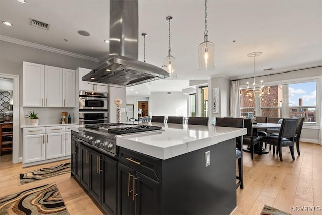 4820 Old Main St Unit 604, Henrico, VA 23231 - kitchen featuring island range hood, stainless steel appliances, white cabinetry, a kitchen island, and ornamental molding