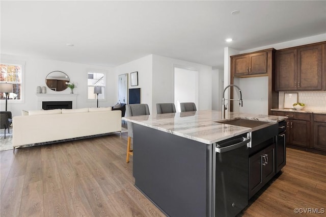 11183 Pinewild Dr, Providence Forge, VA 23140 - kitchen featuring stainless steel dishwasher, a sink, backsplash, a kitchen breakfast bar, and wood finished floors