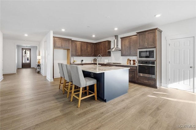 11183 Pinewild Dr, Providence Forge, VA 23140 - kitchen featuring appliances with stainless steel finishes, wall chimney exhaust hood, a sink, light wood-style floors, and recessed lighting