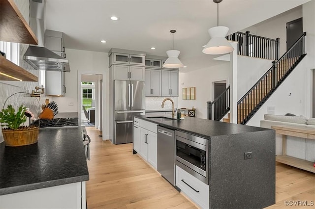 333 Pond View Ln, Goochland, VA 23103 - kitchen with appliances with stainless steel finishes, dark countertops, wall chimney range hood, light wood-style flooring, and recessed lighting