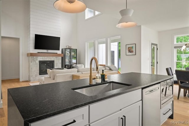 333 Pond View Ln, Goochland, VA 23103 - kitchen with dishwasher, light wood-type flooring, open floor plan, white cabinetry, and a glass covered fireplace