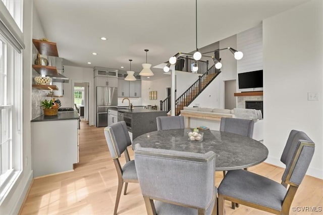 333 Pond View Ln, Goochland, VA 23103 - dining area featuring a tile fireplace, light wood-style flooring, recessed lighting, and stairway
