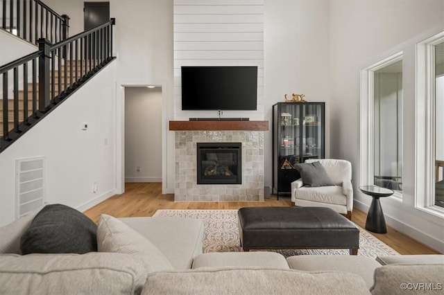 333 Pond View Ln, Goochland, VA 23103 - living area with wood finished floors, stairway, a tiled fireplace, and a high ceiling