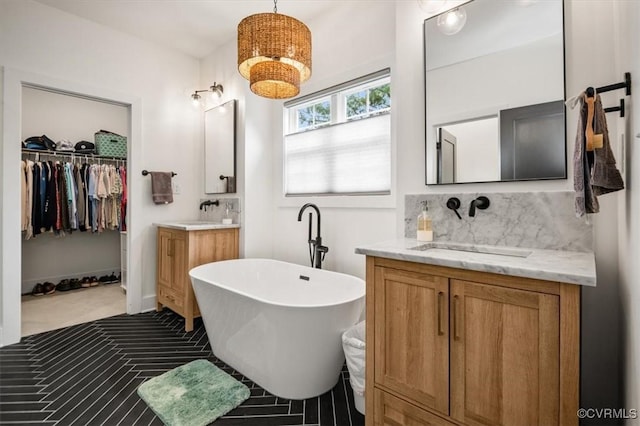 333 Pond View Ln, Goochland, VA 23103 - bathroom with two vanities, a freestanding bath, a walk in closet, and decorative backsplash