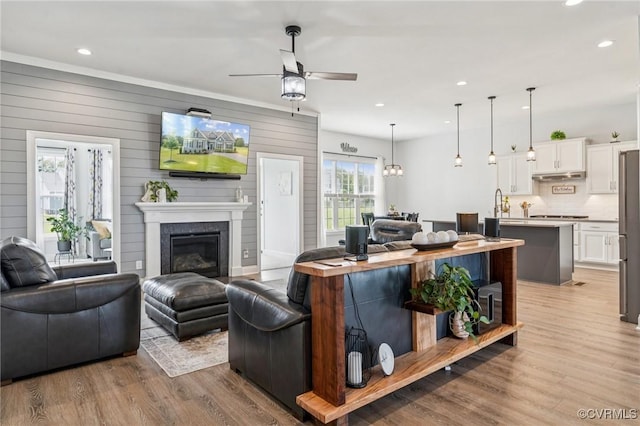 3381 Holywell Cir, Powhatan, VA 23139 - living area with ceiling fan, light wood-style floors, recessed lighting, a glass covered fireplace, and wooden walls