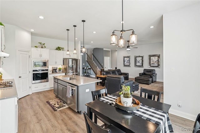 3381 Holywell Cir, Powhatan, VA 23139 - kitchen with appliances with stainless steel finishes, light wood-style flooring, light countertops, white cabinets, and pendant lighting