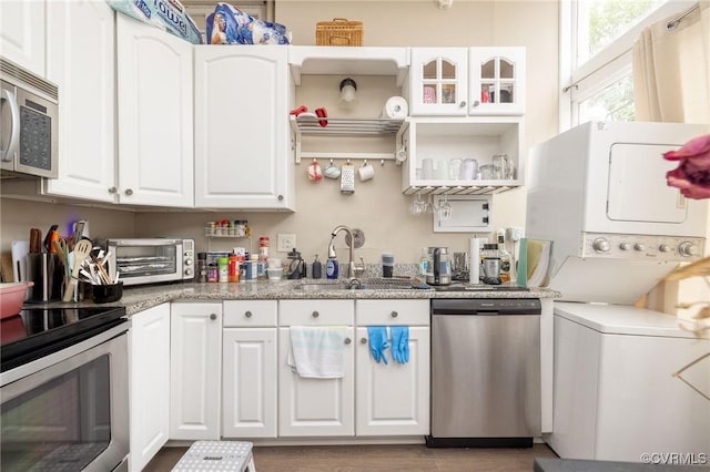 1701 W Leigh St, Richmond, VA 23220 - kitchen featuring stainless steel appliances, a sink, stacked washer / dryer, and white cabinets