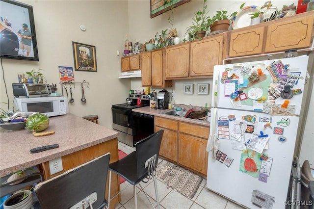 1701 W Leigh St, Richmond, VA 23220 - kitchen with white appliances, light tile patterned flooring, under cabinet range hood, a sink, and light countertops