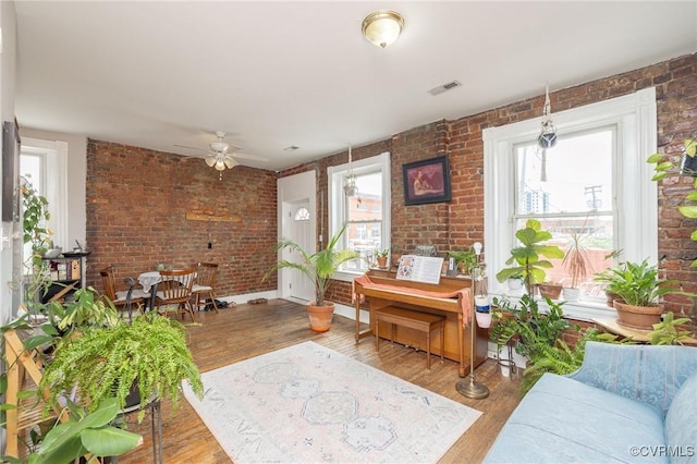 1701 W Leigh St, Richmond, VA 23220 - living area with brick wall, plenty of natural light, wood finished floors, and a ceiling fan