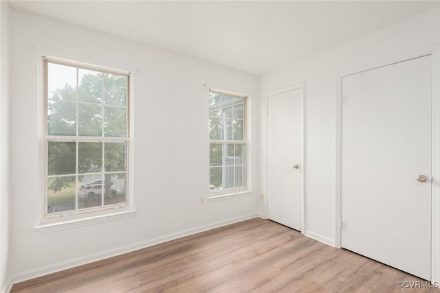 9394 Wind Haven Ct Unit 309, Henrico, VA 23060 - unfurnished bedroom featuring light wood-type flooring, multiple windows, and baseboards
