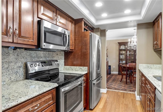 2956 Hathaway Rd Unit 803, Richmond, VA 23225 - kitchen featuring stainless steel appliances, light wood-style floors, decorative backsplash, a tray ceiling, and light stone countertops