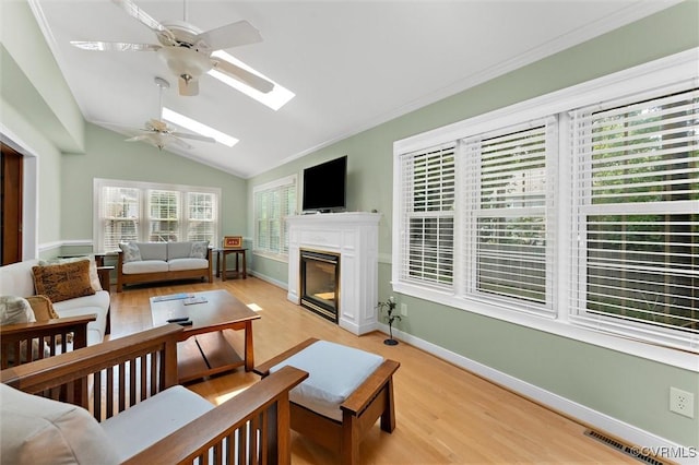 2730 Dalkeith Dr, Henrico, VA 23233 - living area featuring a ceiling fan, light wood-style floors, a skylight, lofted ceiling, and a glass covered fireplace