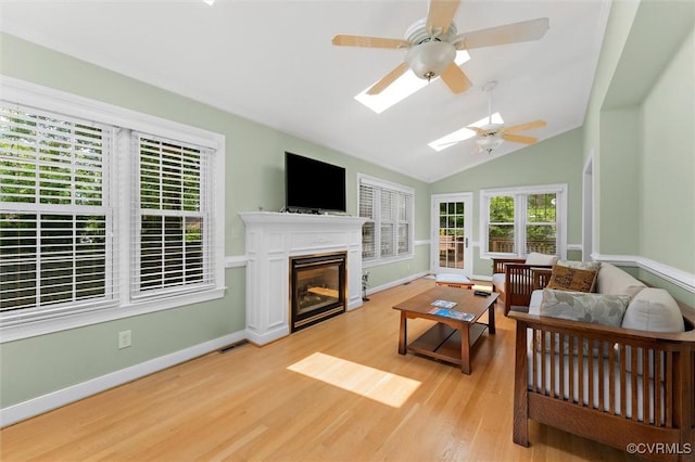 2730 Dalkeith Dr, Henrico, VA 23233 - living room with light wood finished floors, a ceiling fan, a glass covered fireplace, vaulted ceiling, and a skylight