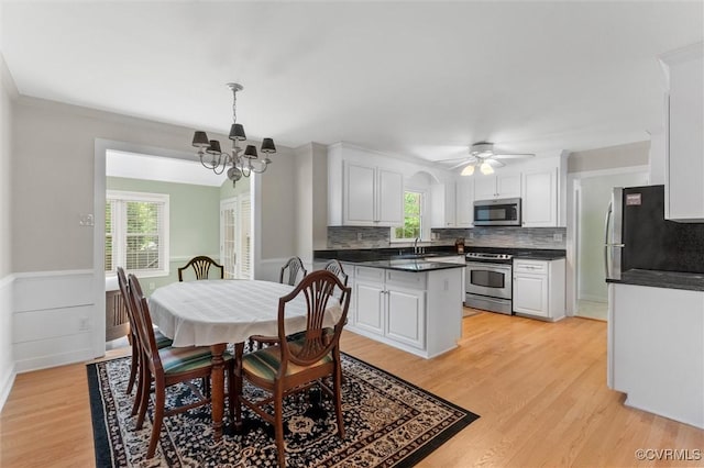 2730 Dalkeith Dr, Henrico, VA 23233 - dining space with light wood-type flooring, a chandelier, a ceiling fan, and a wainscoted wall
