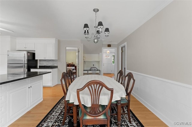 2730 Dalkeith Dr, Henrico, VA 23233 - dining area featuring a chandelier, light wood-style flooring, a wainscoted wall, and crown molding