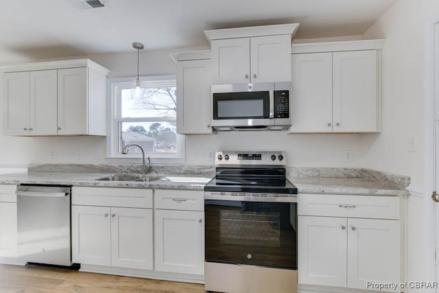 525 Helm Dr, Newport News, VA 23602 - kitchen with appliances with stainless steel finishes, a sink, white cabinets, and decorative light fixtures