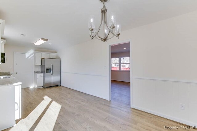 525 Helm Dr, Newport News, VA 23602 - kitchen featuring stainless steel fridge, white cabinets, a chandelier, light wood-style flooring, and pendant lighting