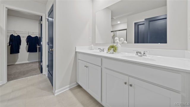 111 Leonard Ct, King William, VA 23009 - bathroom with double vanity, baseboards, a shower with shower door, a walk in closet, and tile patterned floors