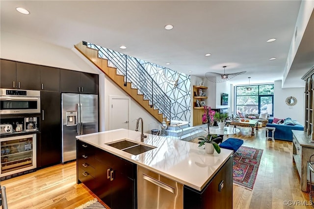 26171/2 Floyd Ave, Richmond, VA 23220 - kitchen featuring appliances with stainless steel finishes, open floor plan, a kitchen island with sink, light wood finished floors, and light countertops