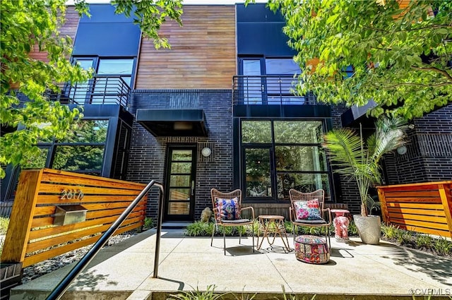 26171/2 Floyd Ave, Richmond, VA 23220 - rear view of house featuring a balcony, a patio, and brick siding
