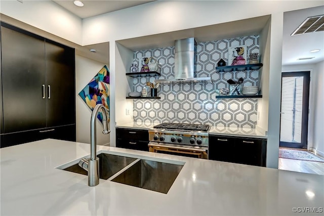 26171/2 Floyd Ave, Richmond, VA 23220 - kitchen with wall chimney range hood, stainless steel stove, dark cabinetry, decorative backsplash, and open shelves