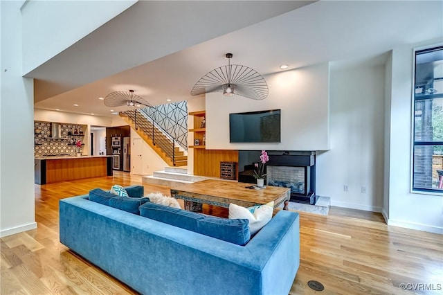 26171/2 Floyd Ave, Richmond, VA 23220 - living room featuring light wood-type flooring, stairs, a fireplace with raised hearth, and recessed lighting